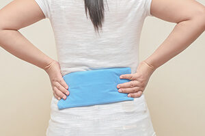 Woman Using a Hot Pack on Her Lower Back